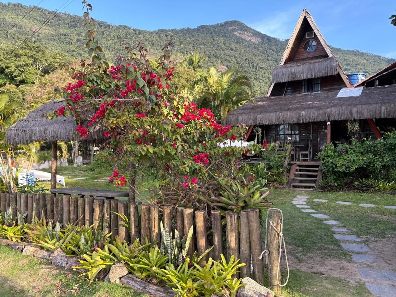 Fachada do Mambembe Ilha Grande entre flores e mata atlântica